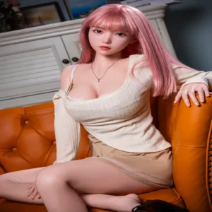ตุ๊กตายางผู้หญิงจริง ผมสีชมพูนั่งบนโซฟาสีส้ม ใส่เสื้อขาวกระโปรงสีน้ำตาล